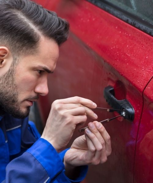 Auto Locksmith Warrington opening a red car by picking the lock.